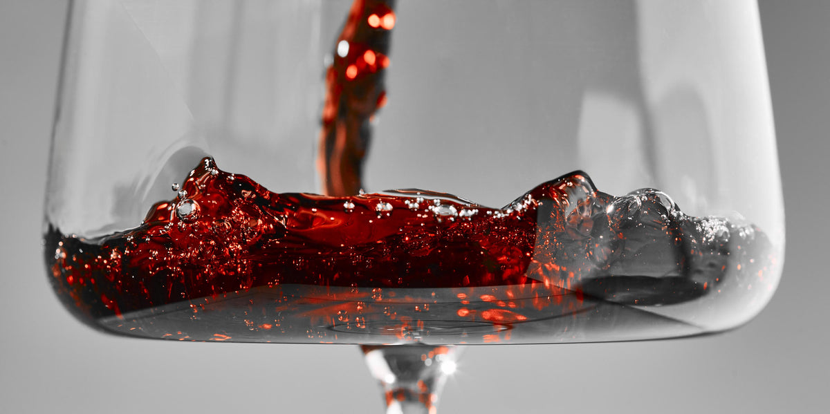 Close-up of a wine glass with red wine on a gray background